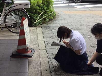 旅行のしおりに何かをメモしています。 旅行のしおりに何かをメモしています。