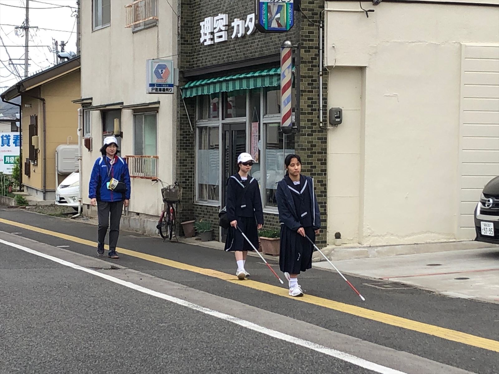 白杖を振って歩道を歩行している様子